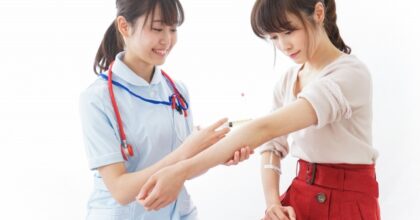 患者の腕に処置をする看護師