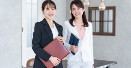 スーツ姿で書類を持つ2人の女性