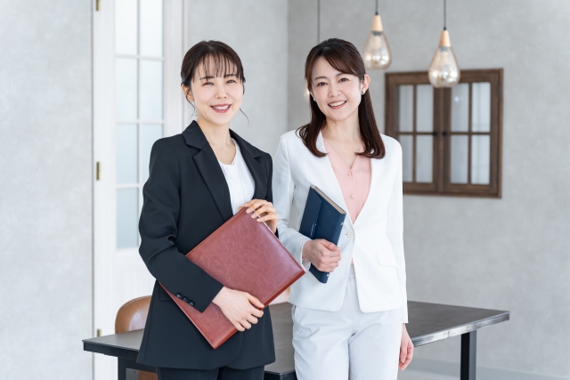 スーツ姿で書類を持つ2人の女性
