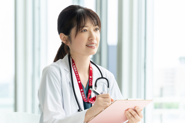 クリップボードに記入する看護師