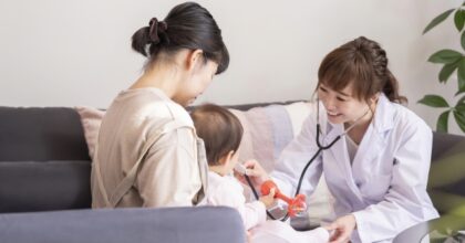 聴診器を当てて子どもを診る白衣の女性