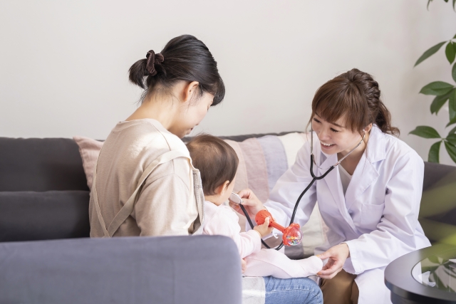 聴診器を当てて子どもを診る白衣の女性